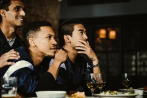 Sports fans sitting at bar in pub drinking beer
